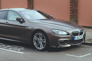 A brown BMW parked by the curb.